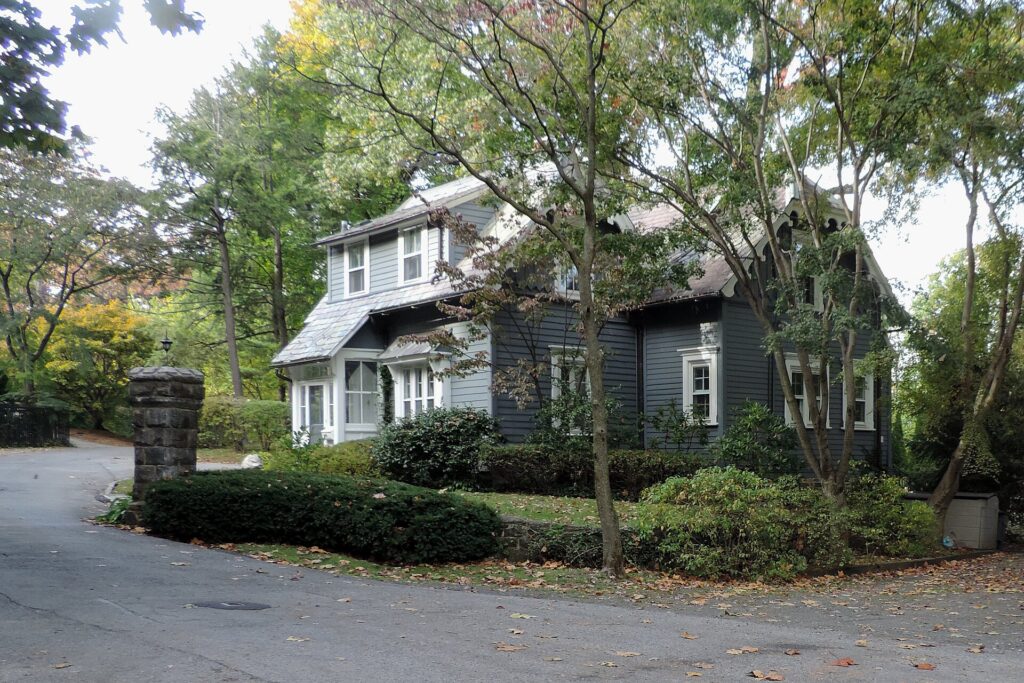A clapboard house among trees on a Riverdale street